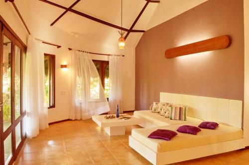 ein Wohnzimmer mit 2 weißen Sofas und einem Tisch in der Unterkunft Refugios Parajuru - Casa Inge in Parajuru