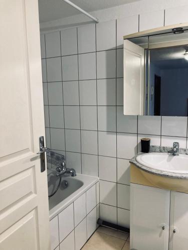 une salle de bain avec un lavabo, une baignoire et un miroir dans l'établissement T1 Tout confort aux porte de Strasbourg, à Strasbourg