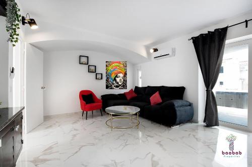 a living room with a black couch and a table at Villa Bellagio in Albufeira