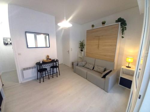 a living room with a couch and a table at Saint Georges de Didonne - FAITES UNE HALTE - STUDIO - quartier boisé in Saint-Georges-de-Didonne