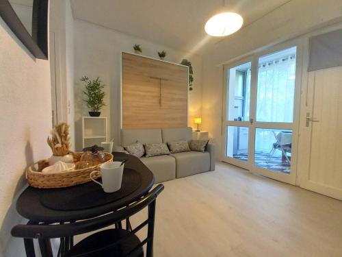 a living room with a couch and a table at Saint Georges de Didonne - FAITES UNE HALTE - STUDIO - quartier boisé in Saint-Georges-de-Didonne