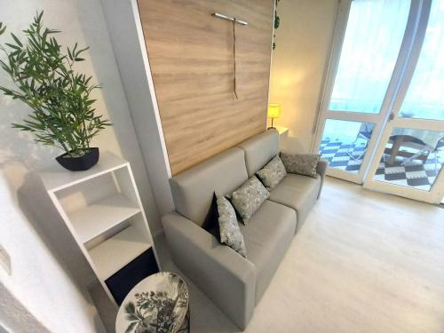 un salon avec un canapé et une plante dans l'établissement Saint Georges de Didonne - FAITES UNE HALTE - STUDIO - quartier boisé, à Saint-Georges-de-Didonne