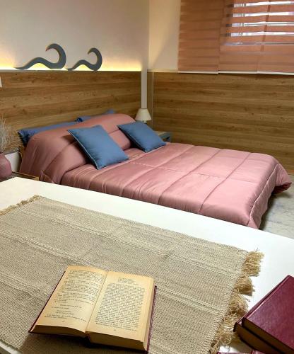 ein Schlafzimmer mit einem Bett mit einem Buch auf einem Tisch in der Unterkunft La Dimora Segreta in Bitetto
