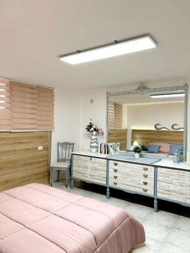 1 dormitorio con espejo grande y cama rosa en La Dimora Segreta, en Bitetto