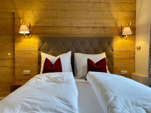 a bedroom with a large white bed with red pillows at Altes Forsthaus - Fewo "Hasenhorn", mit privater Sauna, Todtnau- Feldberg in Todtnau