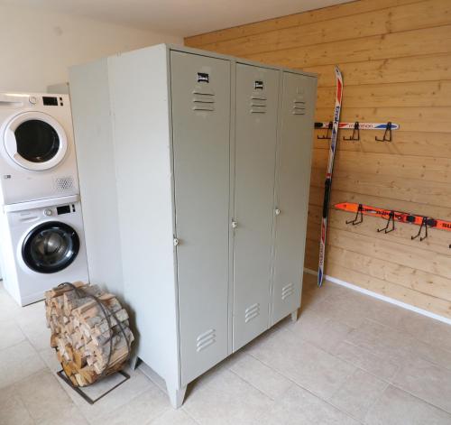 a laundry room with three white cabinets and a washing machine at Altes Forsthaus - Fewo "Hasenhorn", mit privater Sauna, Todtnau- Feldberg in Todtnau