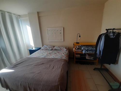 1 dormitorio con 1 cama y TV en la pared en Soul da Lapa Flat Residence, en Río de Janeiro