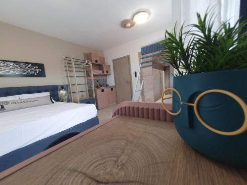 a bedroom with a bed and a potted plant at Olea Luxury Suites in Asprovalta