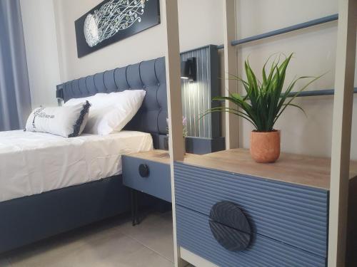 a bedroom with a mirror and a blue dresser with a plant at Olea Luxury Suites in Asprovalta
