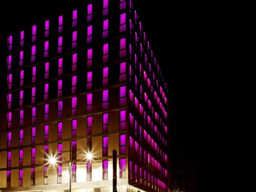 a building with purple lights on the side of it at VISIONAPARTMENTS Berlin - contactless check-in in Berlin