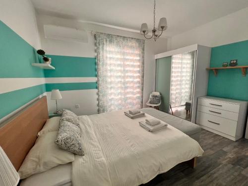 a bedroom with a large bed with blue and white stripes at The Best Apartment on the beach 'Caesar Beach' Bogaz, North Cyprus in Boğaz