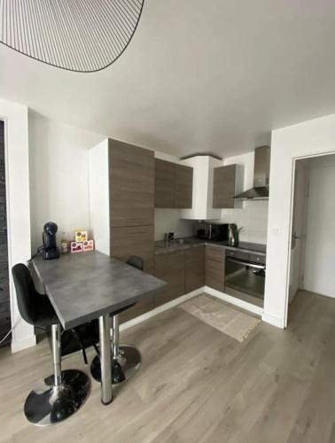 - une cuisine avec une table au milieu d'une pièce dans l'établissement Le Cottage Apaisant, à Ardon