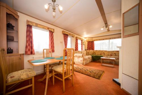 ein Wohnzimmer mit einem Tisch, Stühlen und einem Sofa in der Unterkunft Siedlisko mazury. in Swiętajno
