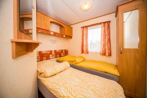 ein kleines Schlafzimmer mit einem Bett und einem Fenster in der Unterkunft Siedlisko mazury. in Swiętajno
