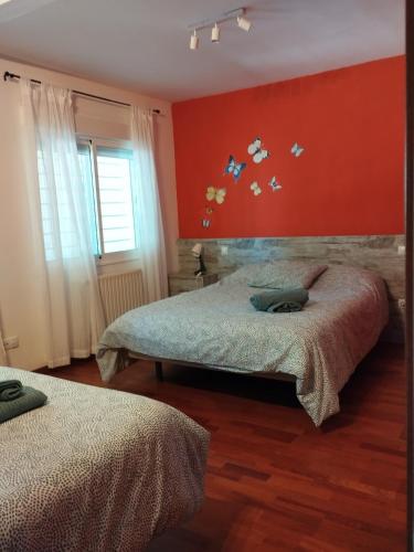 a bedroom with two beds and a red wall at Chalet con JARDIN PUY DU FOU a 10 min ,NO FIESTAS!! in Toledo