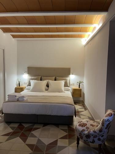 a bedroom with a large bed and a chair at Cortijo San Roque Alojamientos Rurales in Puebla de Don Fadrique