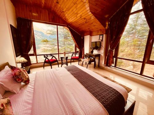 a bedroom with a bed in a room with large windows at Rohtash Guest House in Karnal