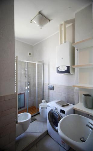 a bathroom with a toilet and a sink and a washing machine at CasaA in La Spezia