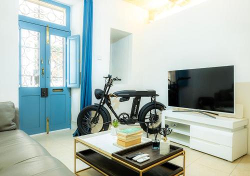 ein Fahrrad geparkt in einem Wohnzimmer mit einem TV in der Unterkunft BR3 - Historic Gem in Cospicua in Cospicua