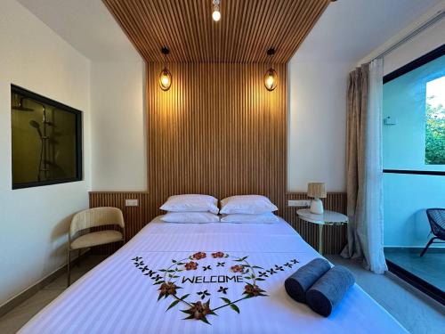 a bedroom with a bed with a white bedspread at Serene Sky Guest house in Thoddoo