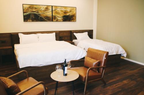 um quarto de hotel com duas camas e uma mesa e cadeiras em Hotel Rozafa em Suharekë