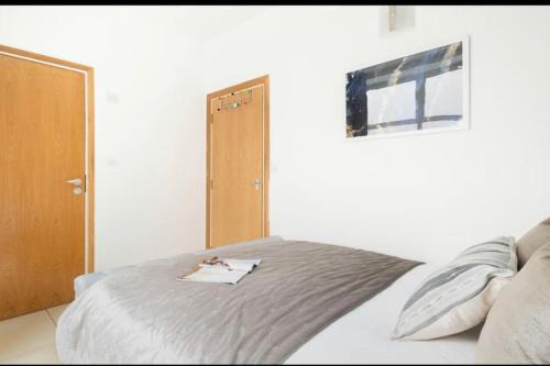 Schlafzimmer mit einem Bett, einem Fenster und einer Tür in der Unterkunft Convenient 2 BDR 2BA Flat in Central London in London