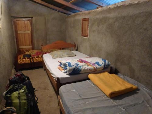 a bedroom with two beds and a backpack in it at Casa Ricardo Sonis in Somoto