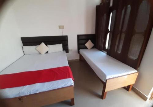 a bedroom with two beds and a bench in it at Hotel surya tourist complex in Barkot