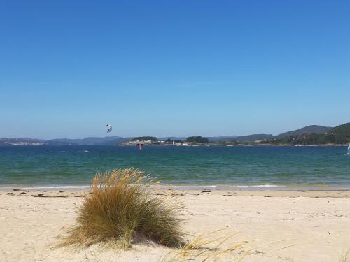 a sandy beach with a kite flying over the ocean at Casa de Antonio in Camariñas
