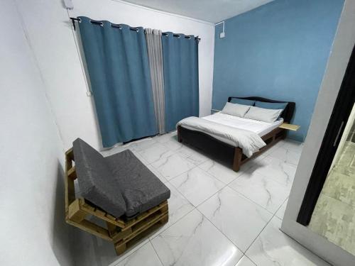 a bedroom with a bed and a blue curtain at Dream's Hôtel in Antsirabe
