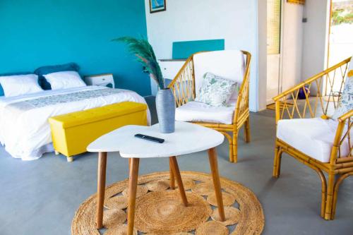 een slaapkamer met een bed en een tafel en stoelen bij Hôtel RIZIKY in Diego Suarez