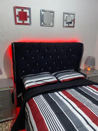- un lit avec une tête de lit noire dans une chambre dans l'établissement Juju House, à Cap-Haïtien