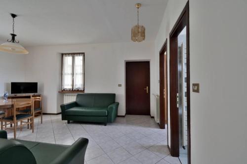 a living room with a green couch and a table at Casa Anna Tornolo Val di Taro in Tornolo