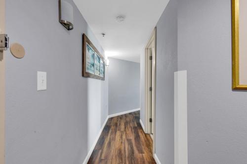 a hallway with white walls and a wooden floor at Stunning Condo with Wall-to-Wall Windows Overlooking Ocean in Myrtle Beach
