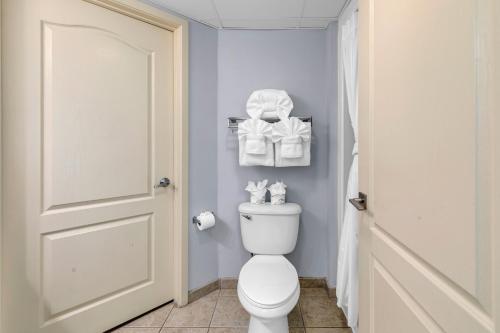 a bathroom with a toilet and towels on the wall at Stunning Condo with Wall-to-Wall Windows Overlooking Ocean in Myrtle Beach