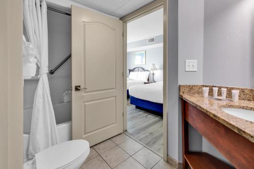 a bathroom with a toilet sink and a bed at Stunning Condo with Wall-to-Wall Windows Overlooking Ocean in Myrtle Beach