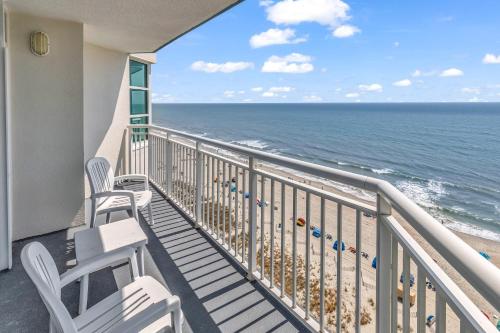 a balcony with chairs and a view of the ocean at Stunning Condo with Wall-to-Wall Windows Overlooking Ocean in Myrtle Beach