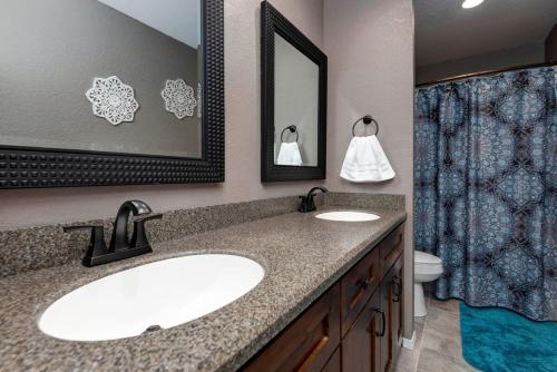 ein Badezimmer mit einem Waschbecken, einem WC und einem Spiegel in der Unterkunft Beautifully Updated w Indoor Pool & Splash Pad Access in Branson