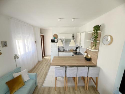 una cucina e un soggiorno con un tavolo e un divano blu di Sea Dream Apartments a Bibinje (Bibigne)