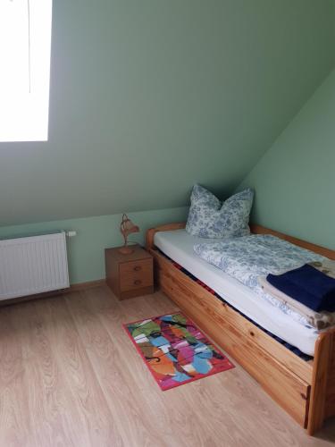 a bedroom with a bed and a rug on the floor at Ferienwohnung am Schlosssee. in Penkun