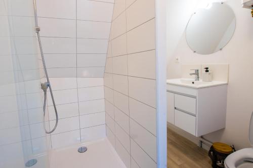 une salle de bain blanche avec une douche et un lavabo dans l'établissement Hesdin Appart Holidays 5, à Hesdin