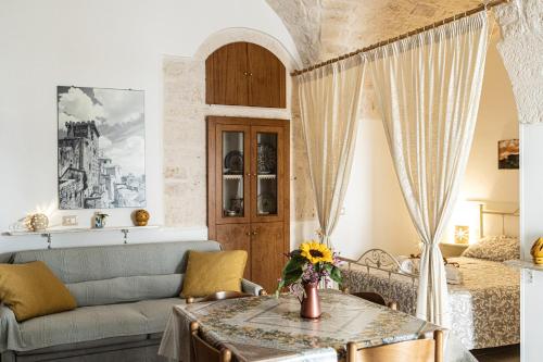 a living room with a couch and a table at CASETTA CLOE house of charm and romance in Ceglie Messapica