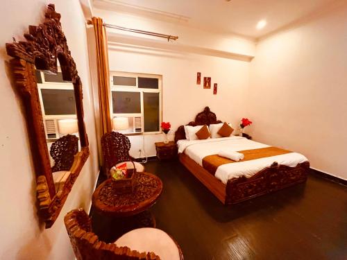 a bedroom with a large bed and a mirror at Sanju Lodge in Hisār