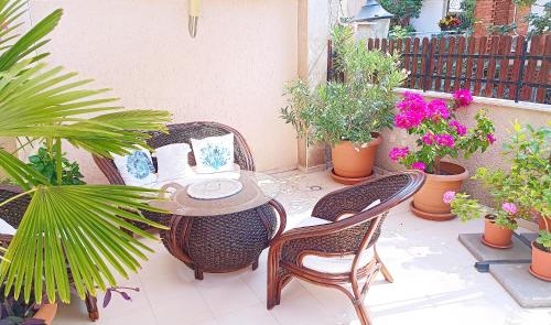 a patio with a table and chairs and potted plants at Villa Rosi in Sozopol