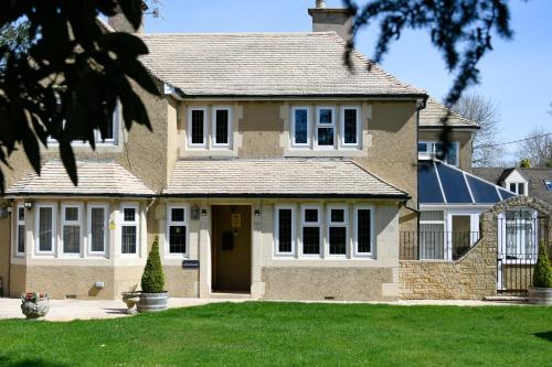 a large brick house with a front yard at Southlands B&B in Bourton on the Water