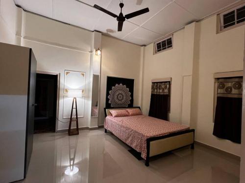 a bedroom with a bed and a ceiling fan at Palm715 Villa in jorhat in Jorhāt