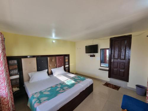 a bedroom with a large bed and a television at SmartValley View Dalhousie-Nature`s Heaven in Dalhousie