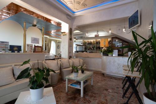 a room with a couch and a table with plants at Hotel Britannia in Rimini