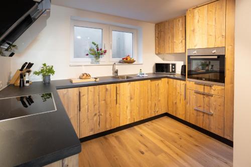 a kitchen with wooden cabinets and stainless steel appliances at Sope Skylodge 02 - Selina's & Gentjana's Kuckucksnest - Oberried, Schauinsland in Oberried