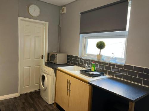 a kitchen with a sink and a washing machine at AA Tyne Apartments in Gateshead